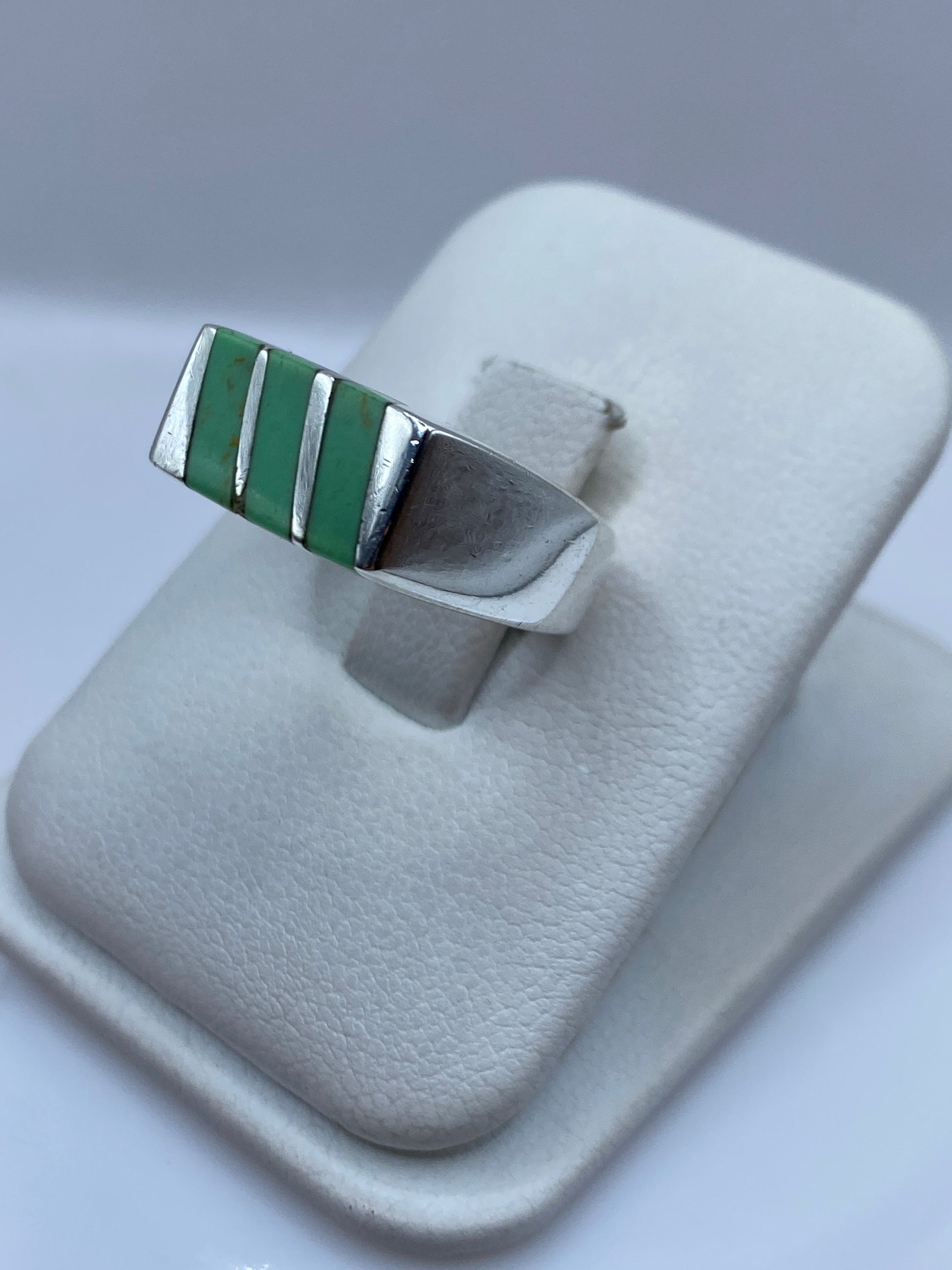 Anillo de plata malaquita verde en dedo, mostrando el diseño arquitectónico y las vetas naturales