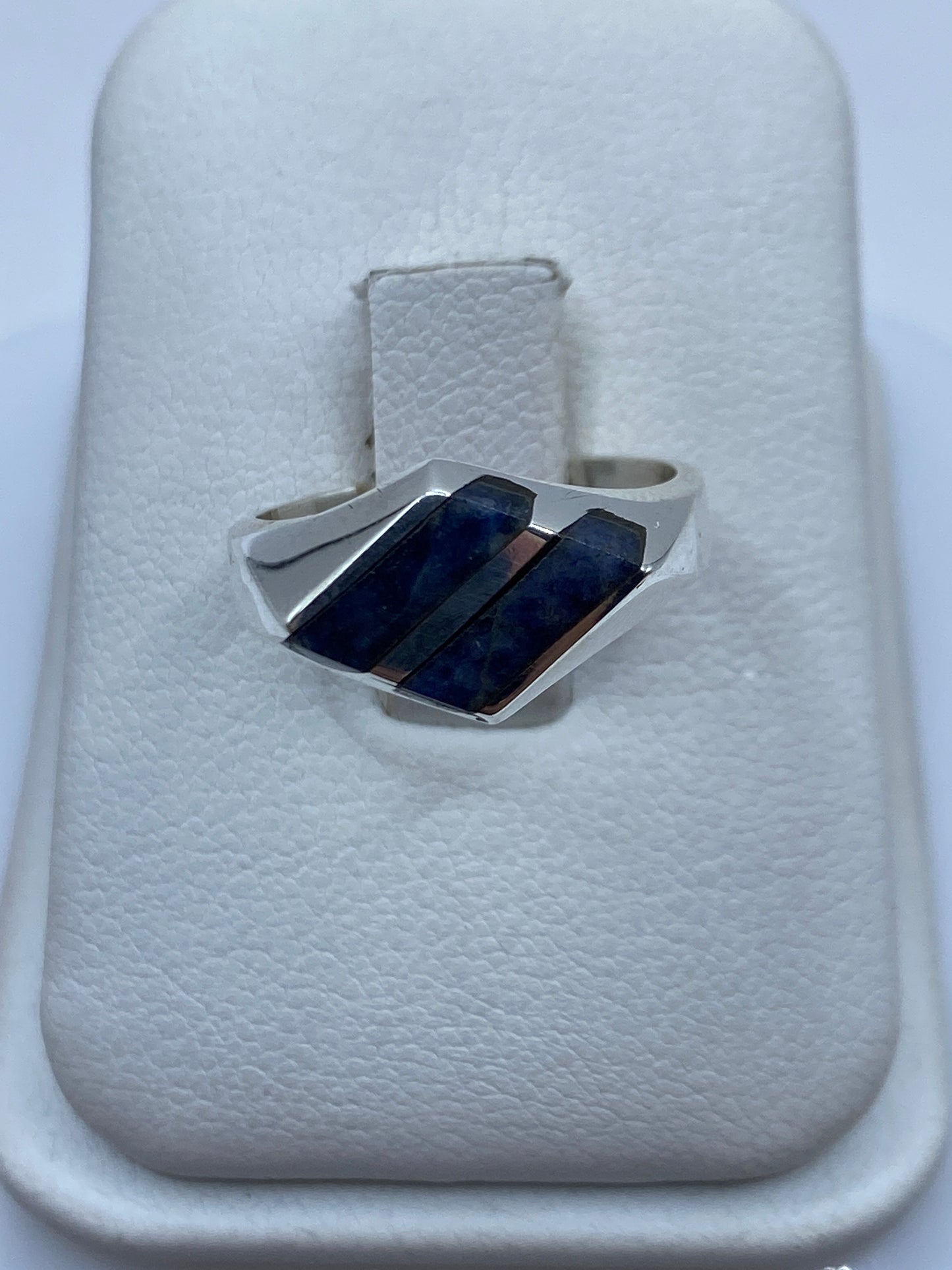 Anillo de plata sello con lapislázuli azul natural en la mano de una persona