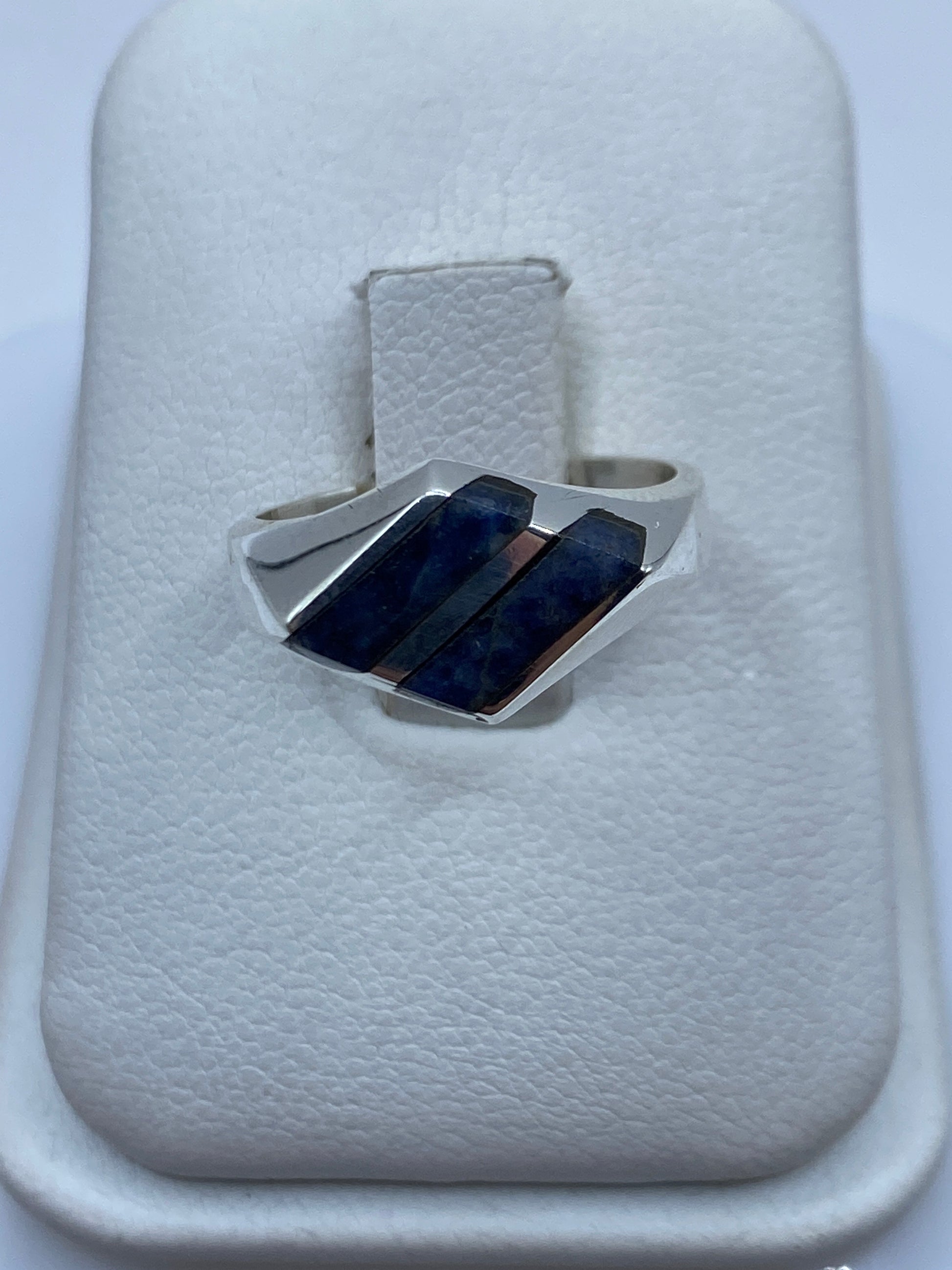 Anillo de plata sello con lapislázuli azul natural en la mano de una persona
