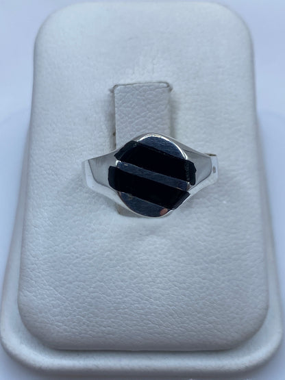 Anillo de plata con ónix negro pulido, vista frontal en estuche blanco