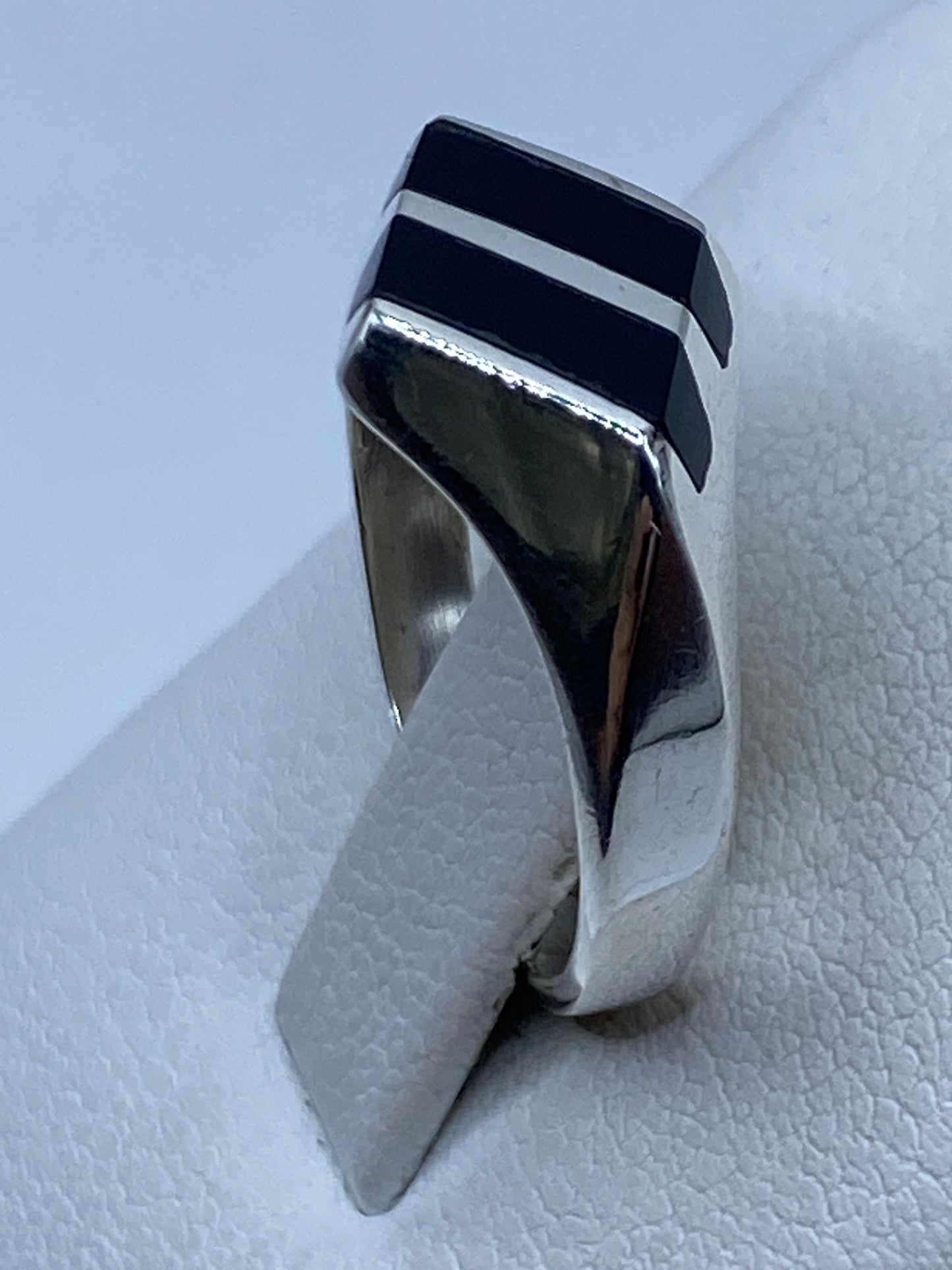 Anillo de plata y ónix puesto en mano, diseño moderno y versátil
