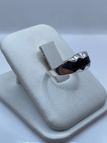 Detalle lateral del anillo minimalista mostrando el marco de plata alrededor de la piedra