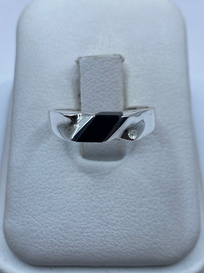 Anillo de plata con ónix negro pulido sobre estuche blanco, vista frontal