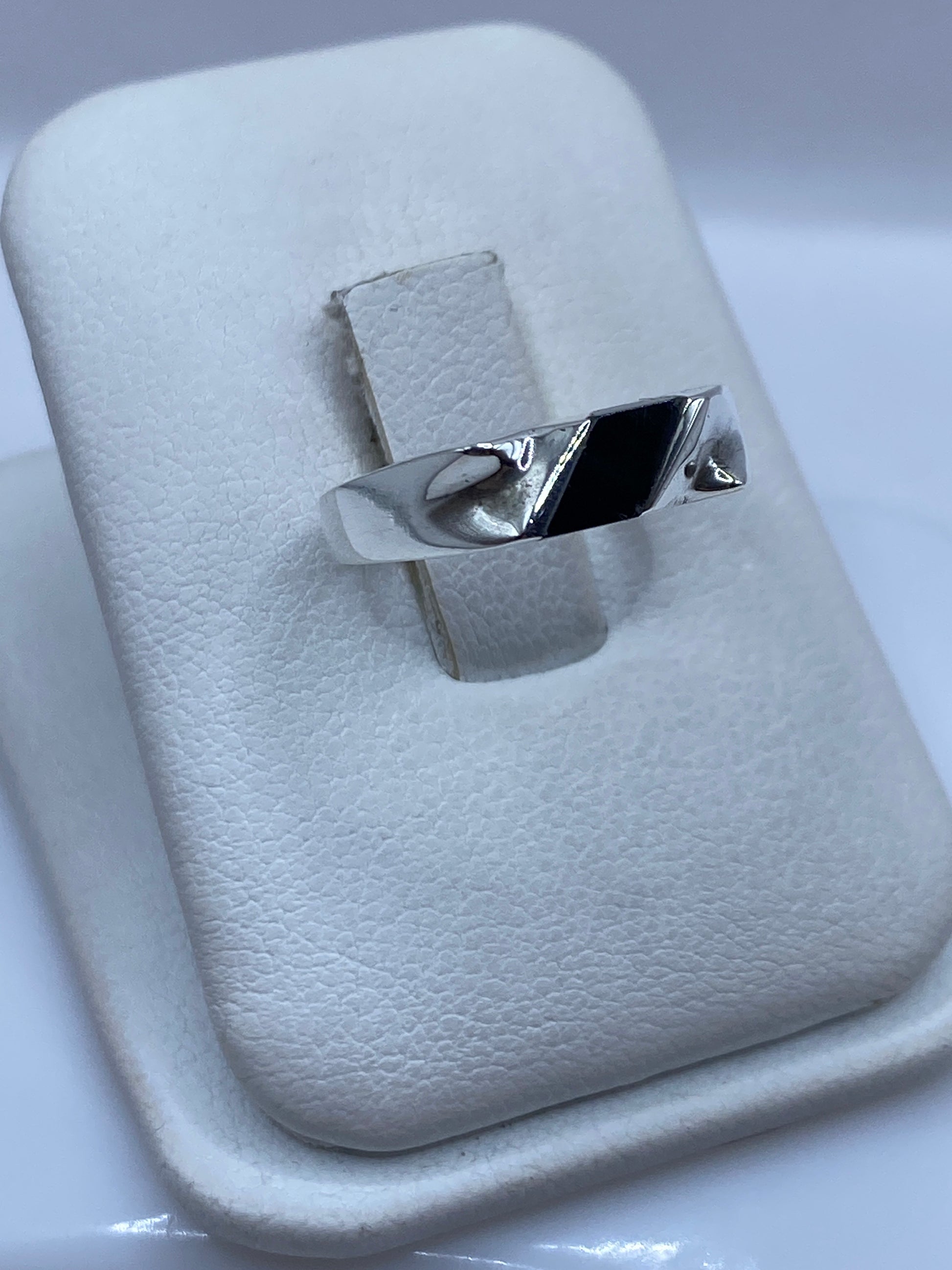 Anillo minimalista plata-ónix en la mano, mostrando el acabado liso y elegante