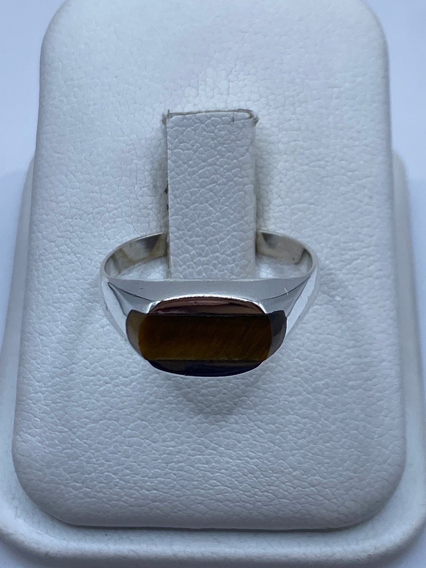 Anillo de plata solitario con piedra café natural en dedo unisex