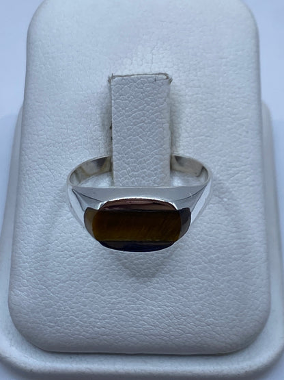 Anillo de plata solitario con piedra café natural en dedo unisex