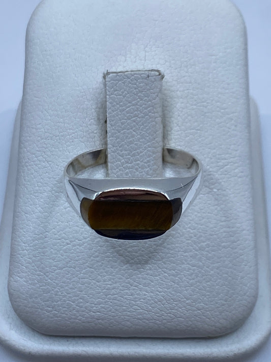 Anillo de plata solitario con piedra café natural en dedo unisex