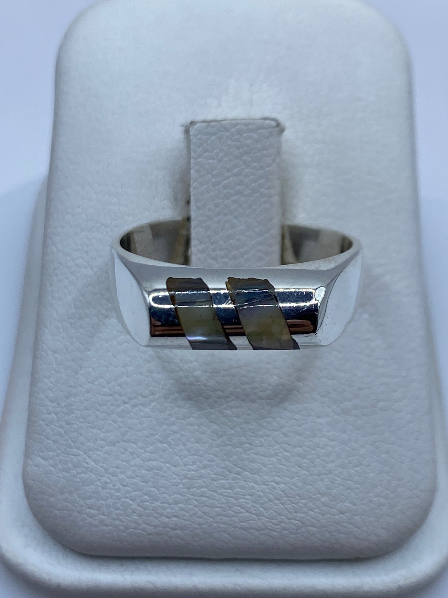 Anillo de plata .925 con bandas geométricas incrustadas sobre fondo blanco