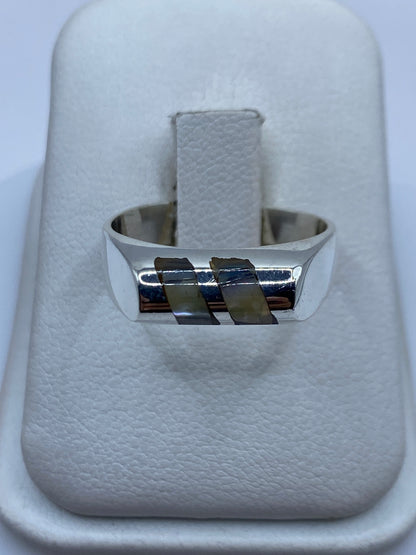 Anillo de plata .925 con bandas geométricas incrustadas sobre fondo blanco