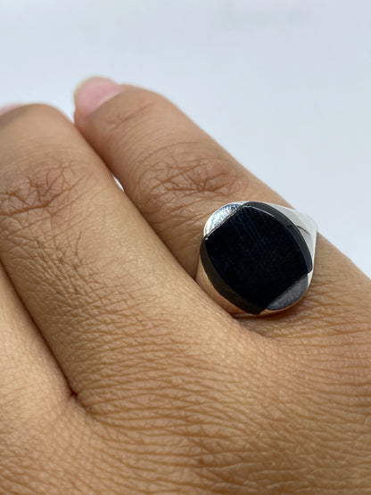 Anillo de plata con ónix negro en mano mostrando el pulido perfecto de la piedra