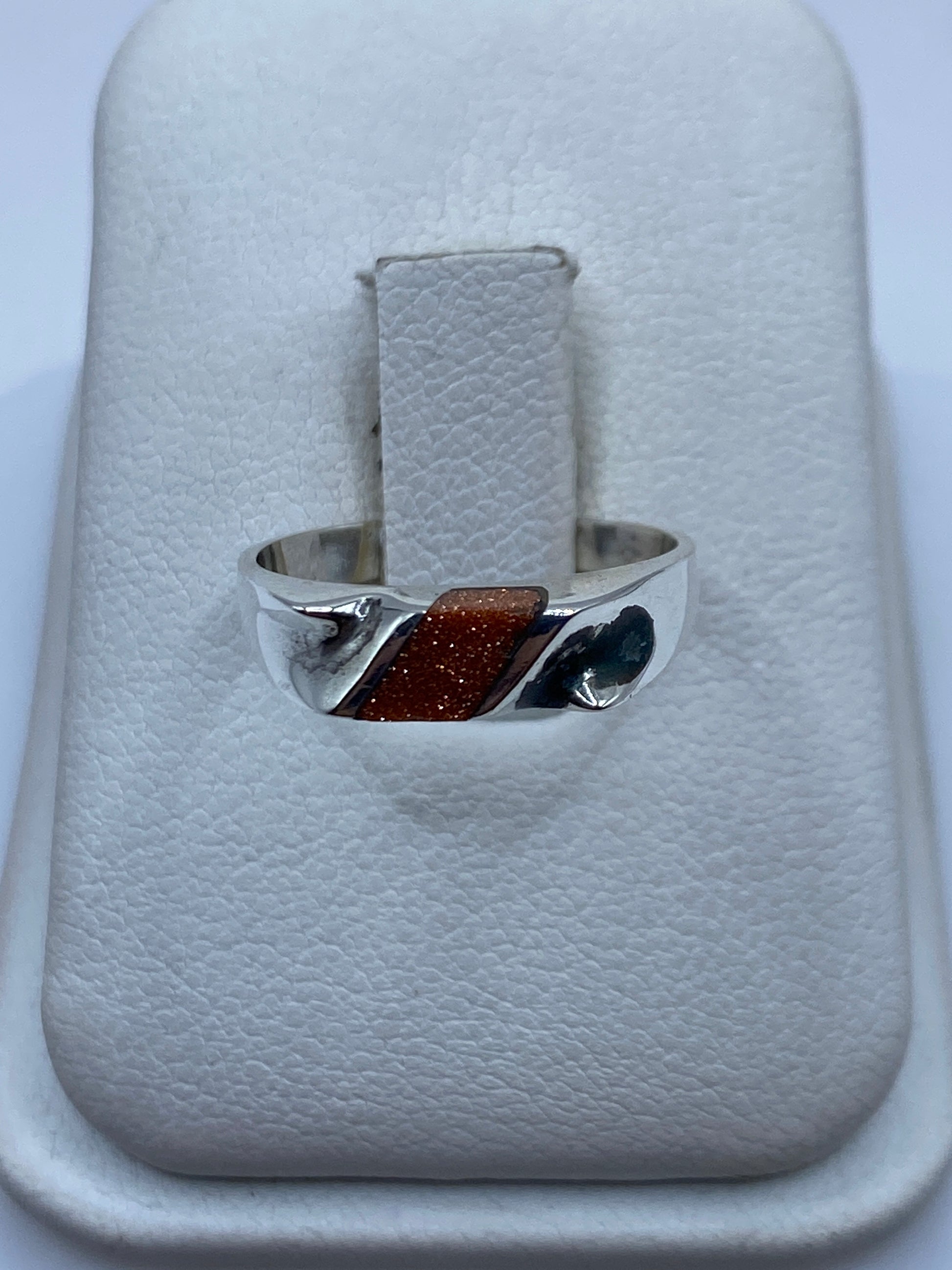 Anillo de plata con onix negro pulido, vista frontal en mano de mujer