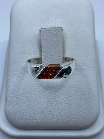 Anillo de plata con onix negro pulido, vista frontal en mano de mujer