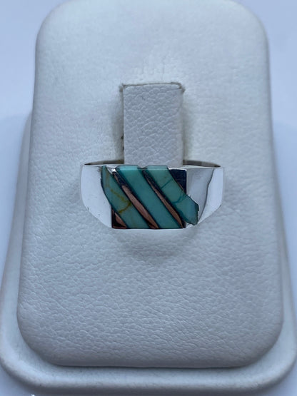 Anillo de plata con piedra azul cielo en diseño geométrico sobre dedo de mujer