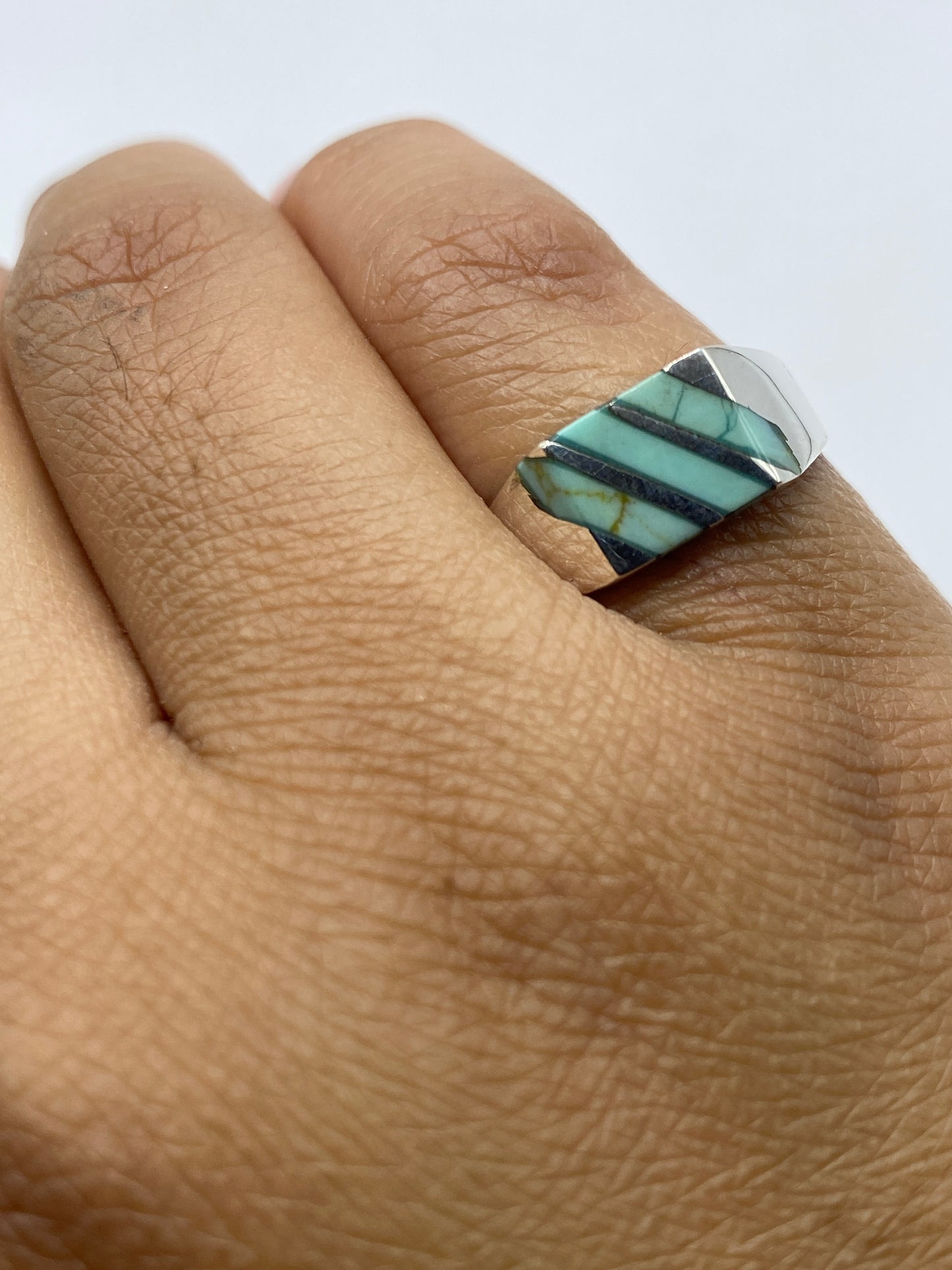 Anillo en plata mostrando el sello 925 y la piedra azul cielo desde el lateral