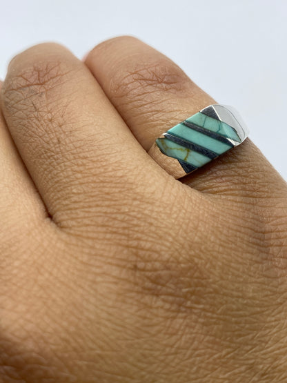 Anillo en plata mostrando el sello 925 y la piedra azul cielo desde el lateral