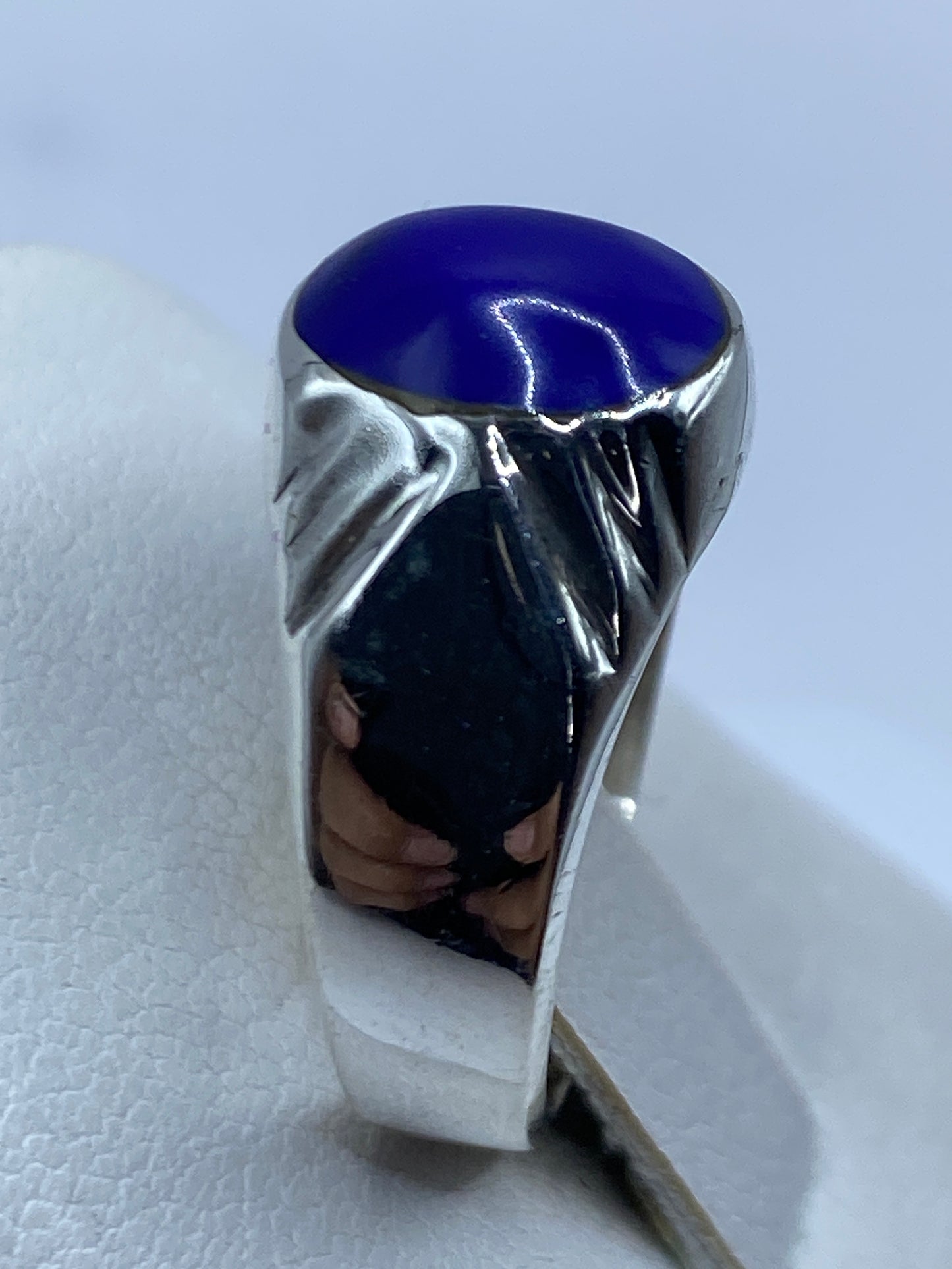 Detalle de la piedra azul pulida en el anillo, vista frontal con brillo profundo
