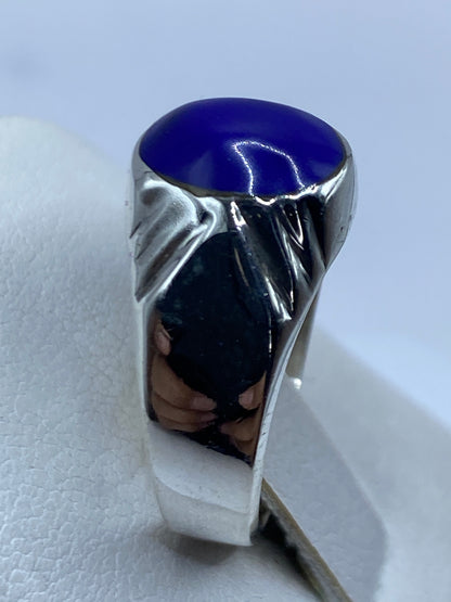 Detalle de la piedra azul pulida en el anillo, vista frontal con brillo profundo