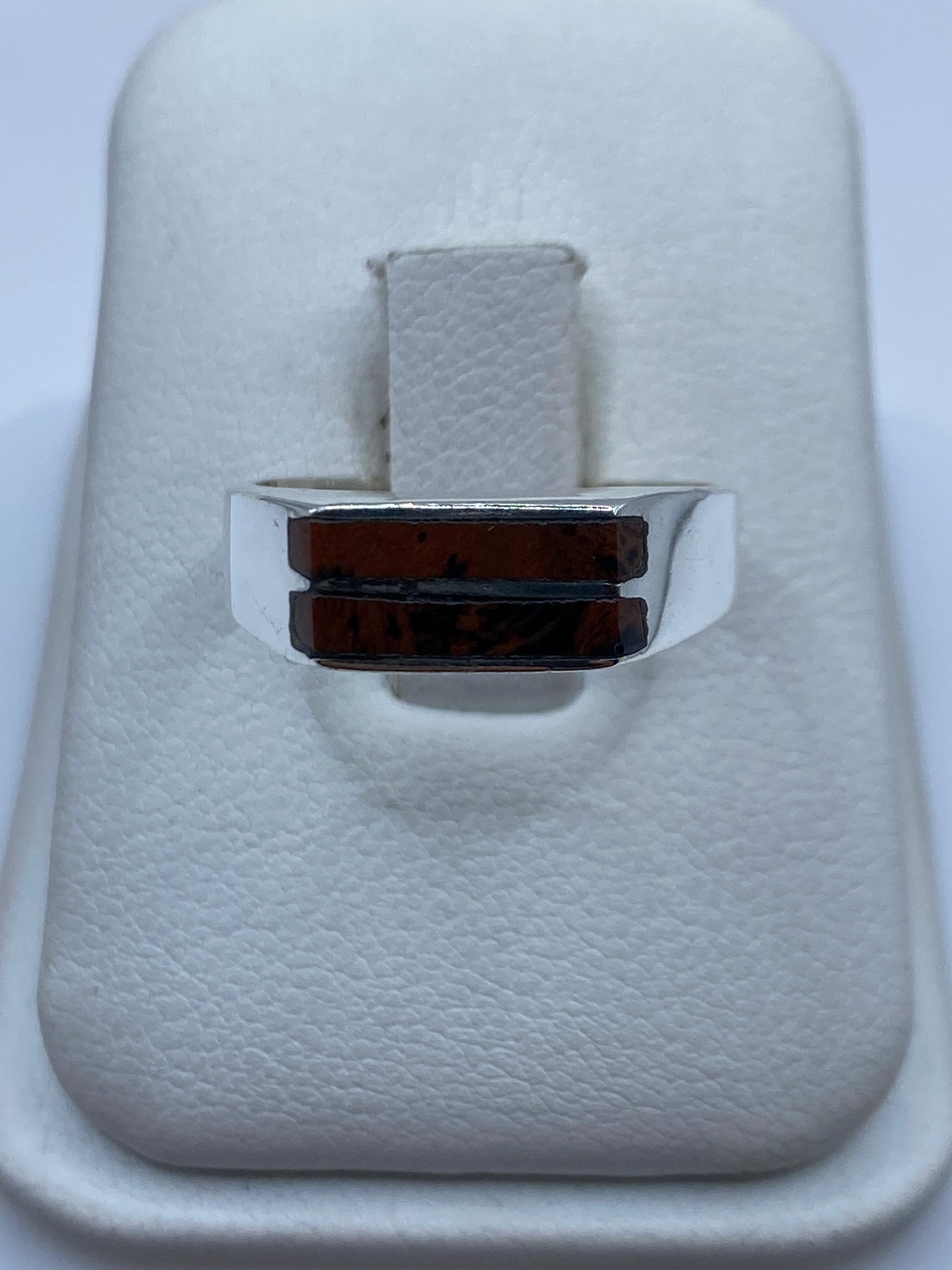 Anillo de plata con piedra café sobre fondo blanco, vista de frente