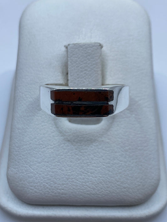 Anillo de plata con piedra café sobre fondo blanco, vista de frente