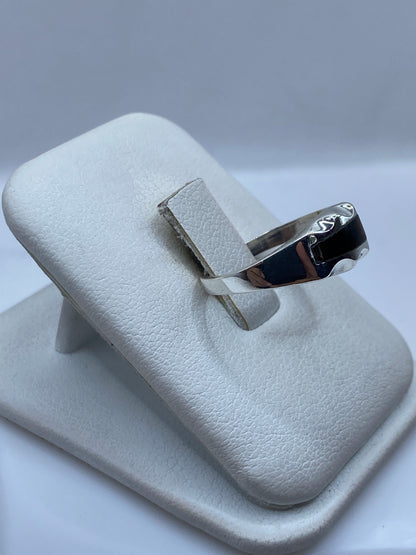 Detalle frontal del anillo minimalista mostrando la piedra café y el pulido de la plata