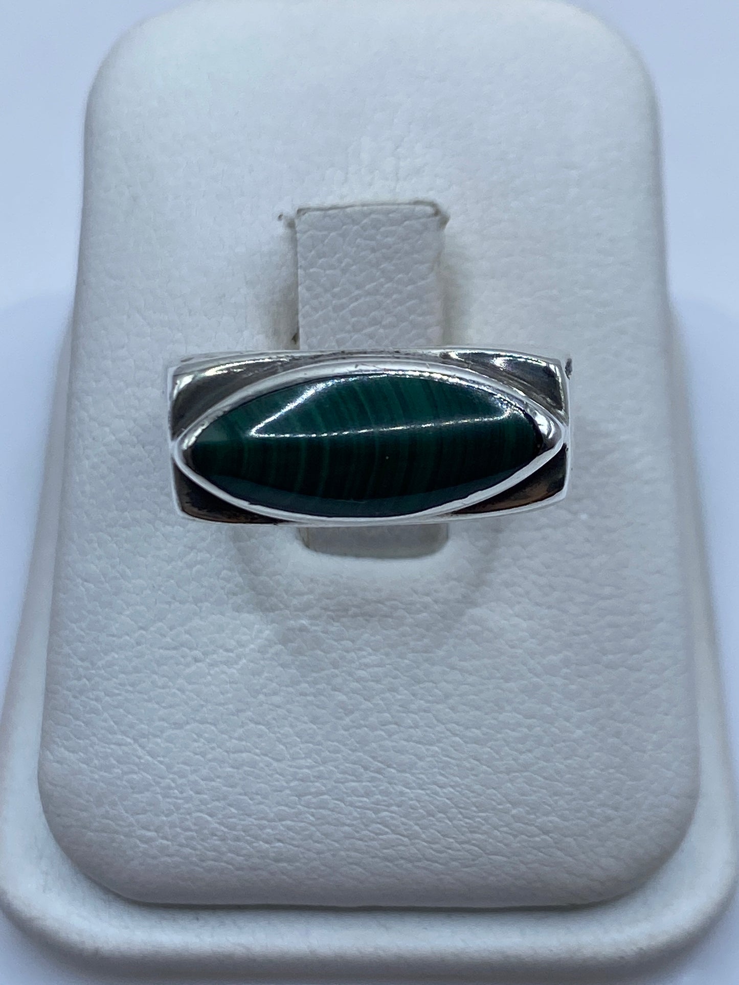 Anillo de plata .925 con malaquita verde ovalada engastada, vista frontal en joyero blanco