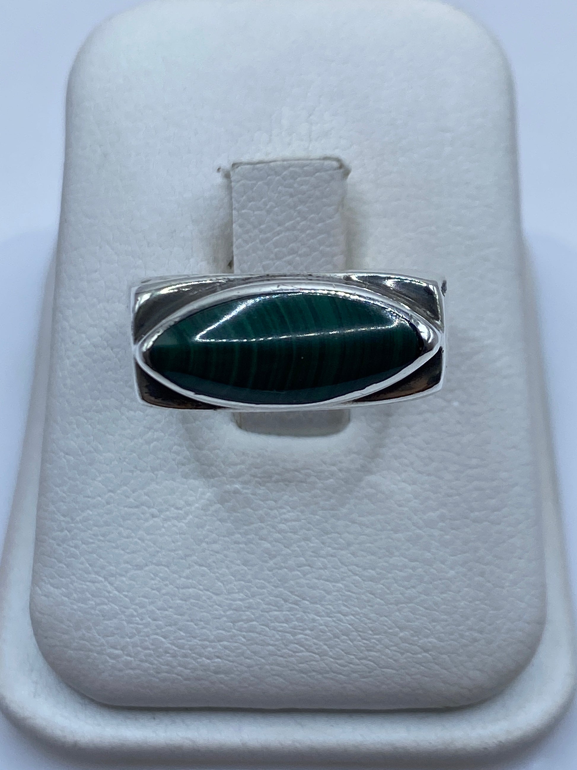 Anillo de plata .925 con malaquita verde ovalada engastada, vista frontal en joyero blanco