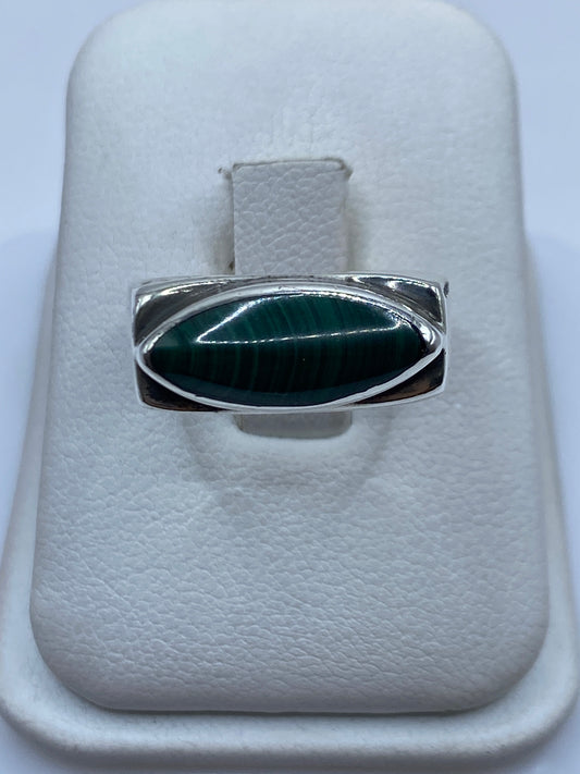 Anillo de plata .925 con malaquita verde ovalada engastada, vista frontal en joyero blanco