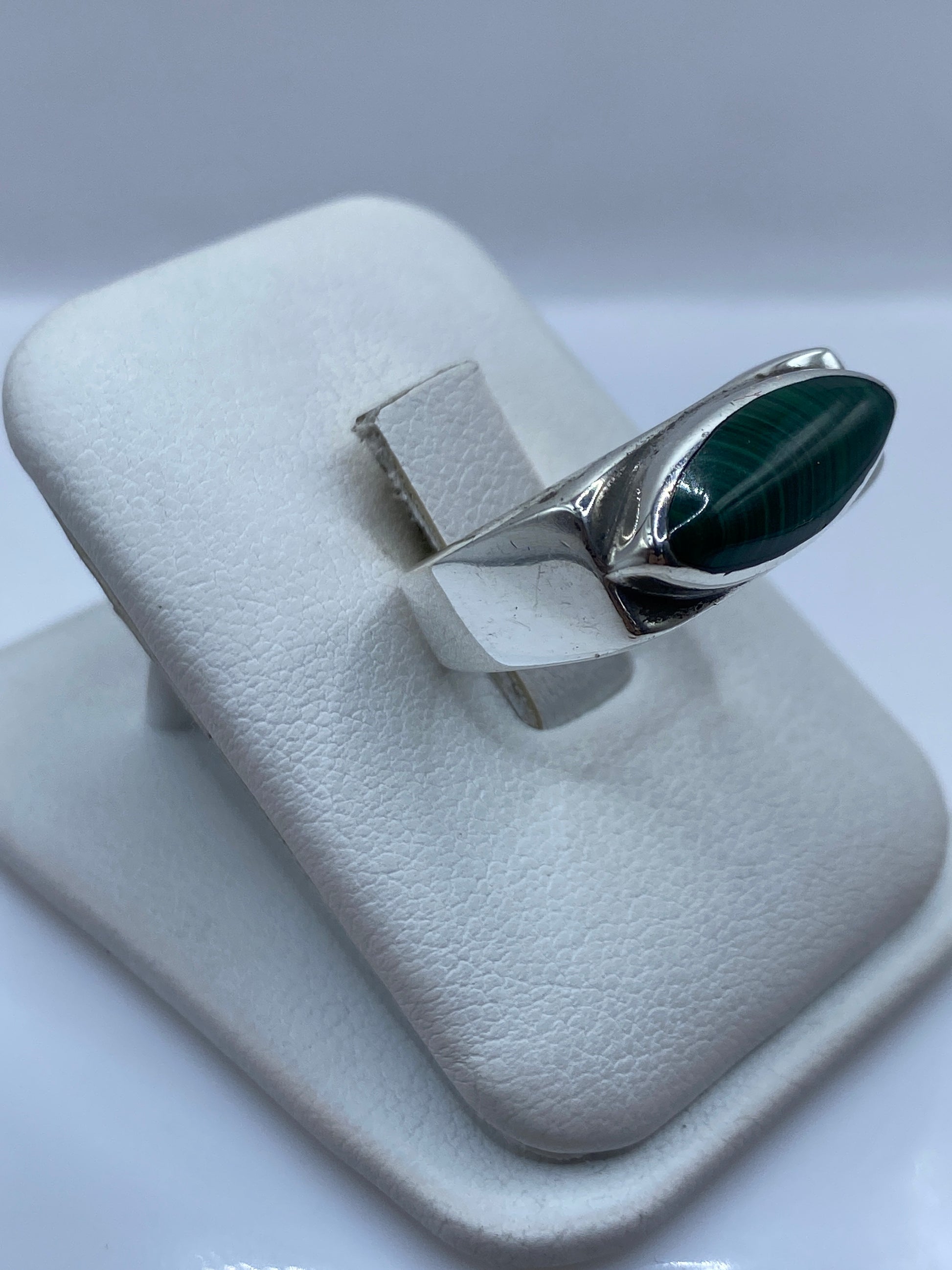 Detalle lateral del anillo mostrando la banda ancha de plata pulida y la malaquita