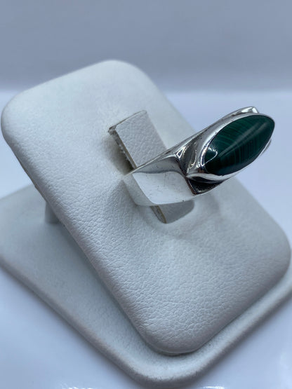 Detalle lateral del anillo mostrando la banda ancha de plata pulida y la malaquita