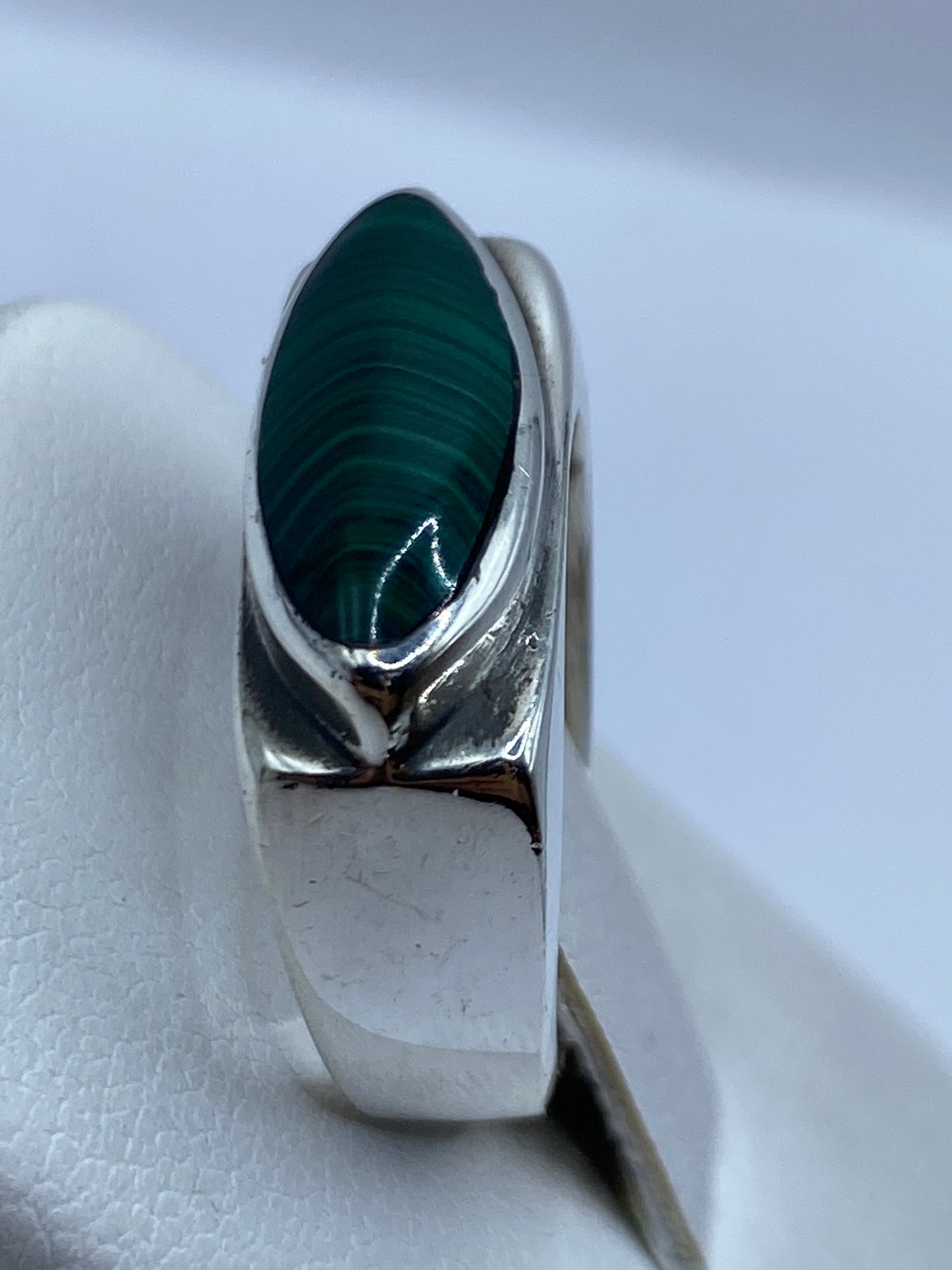 Anillo de malaquita en la mano de una persona adulta mostrando el color verde natural