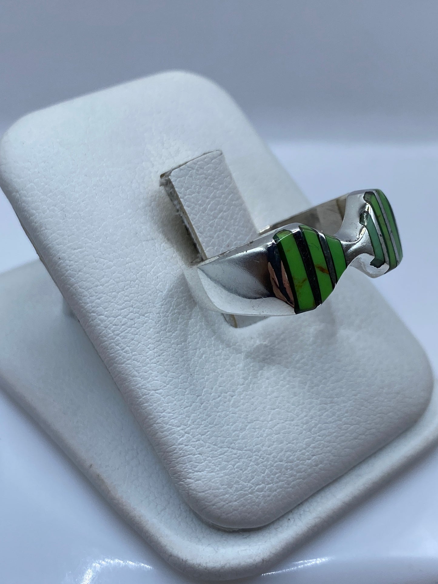 Detalle lateral del anillo moderno mostrando el engaste de la piedra verde en plata .925