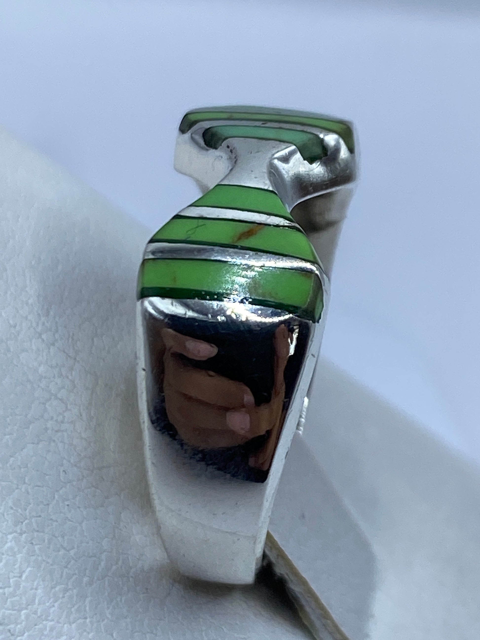 Anillo solitario verde en mano de mujer, uso diario, vista natural