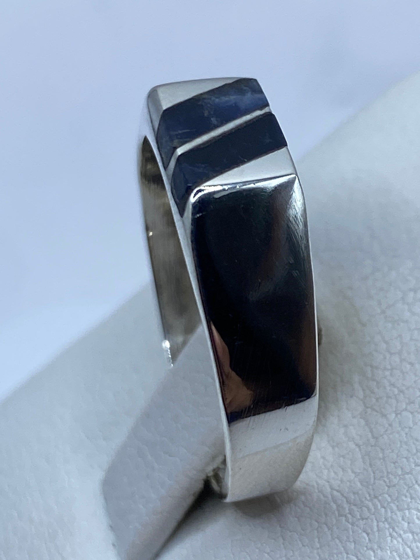 Detalle de lapislázuli natural azul con vetas doradas en anillo de plata