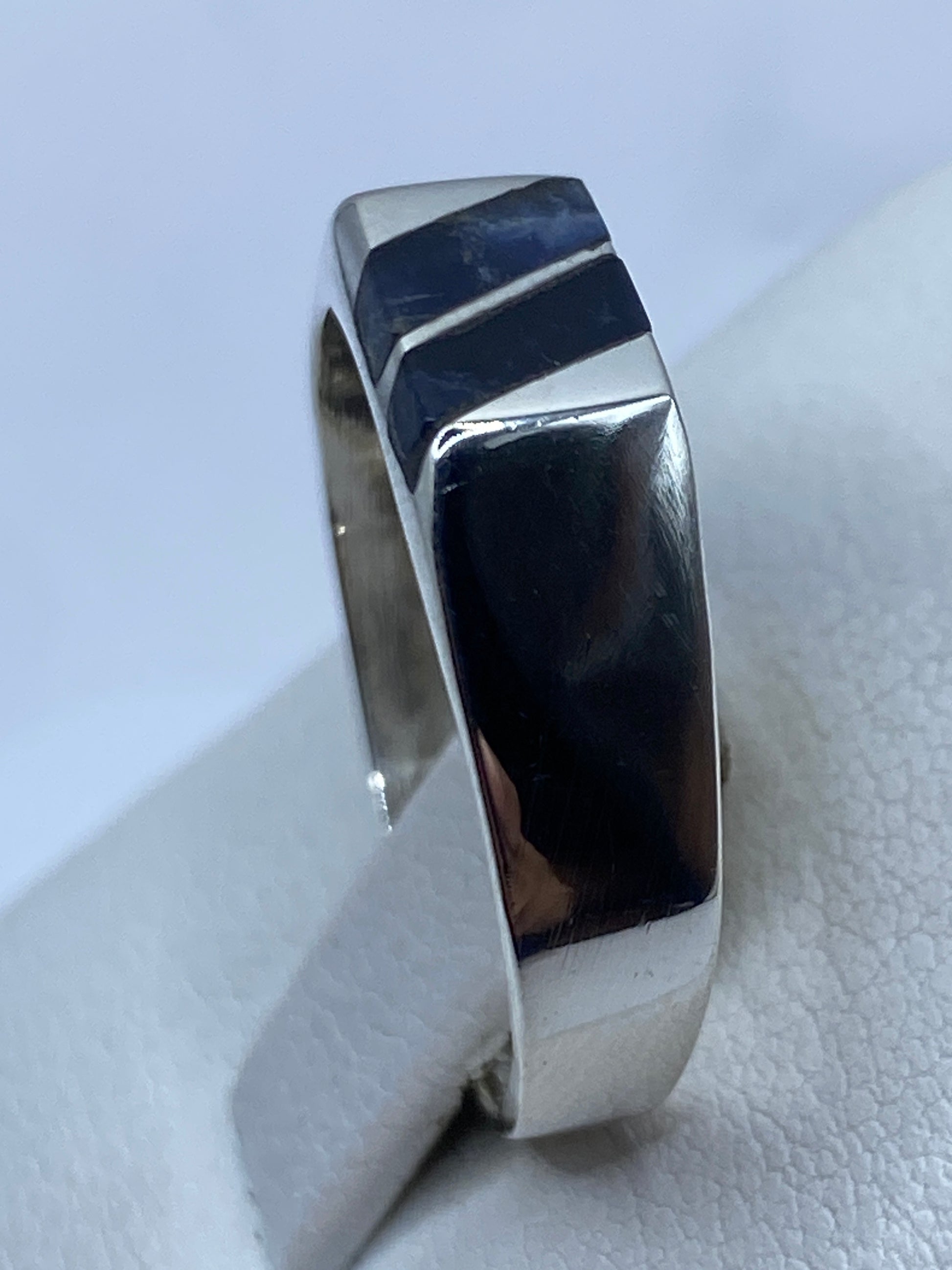 Detalle de lapislázuli natural azul con vetas doradas en anillo de plata