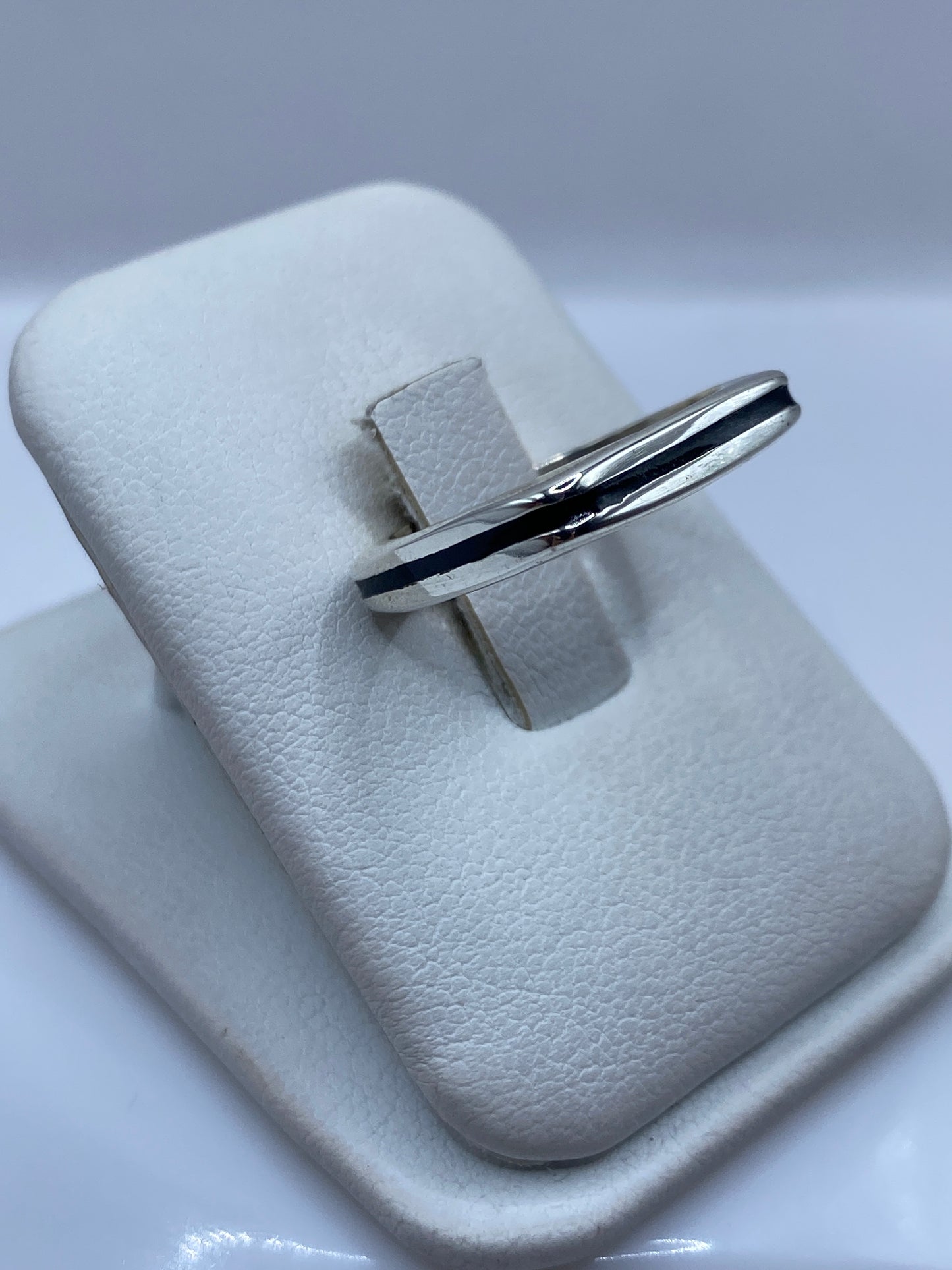 Anillo minimalista unisex en plata pura con piedra negra, detalle del diseño geométrico