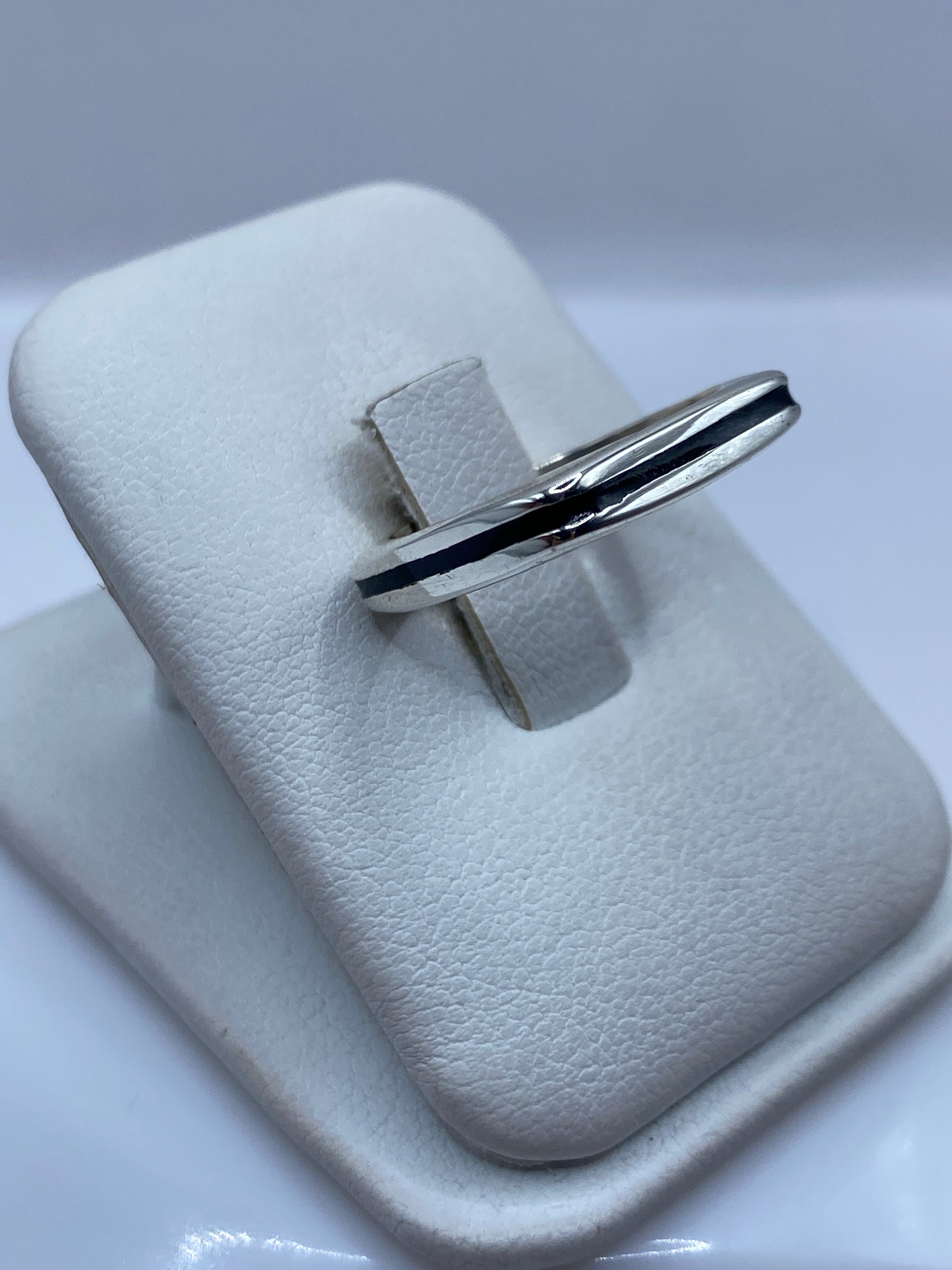 Anillo minimalista unisex en plata pura con piedra negra, detalle del diseño geométrico