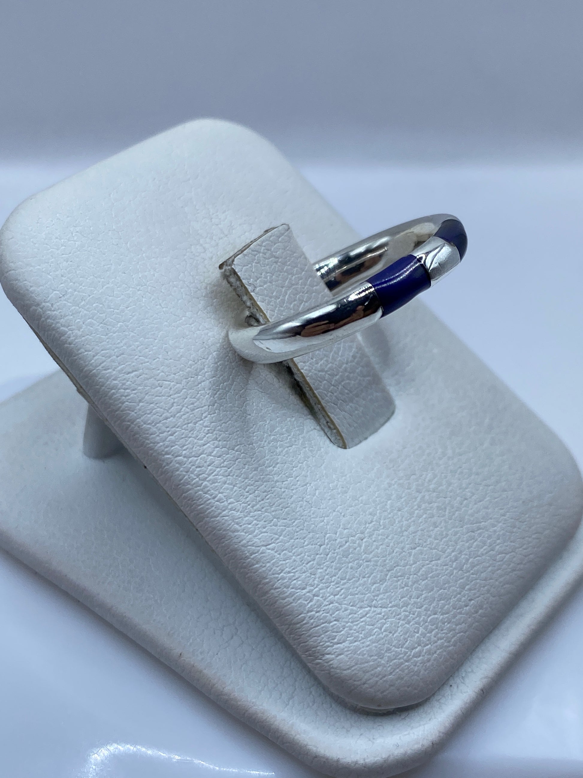 Detalle lateral del anillo minimalista mostrando el engaste de la piedra azul