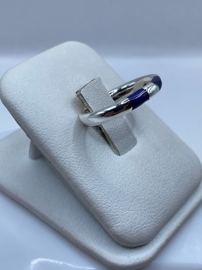Detalle lateral del anillo minimalista mostrando el engaste de la piedra azul