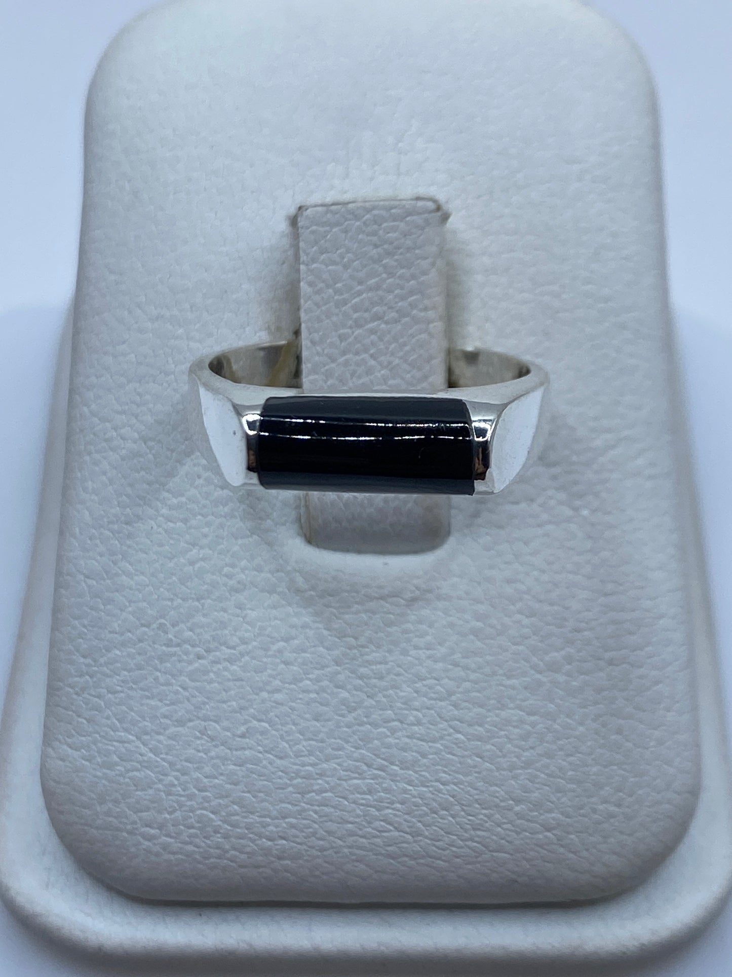 Anillo de plata .925 con ónix negro rectangular en mano de mujer, vista frontal