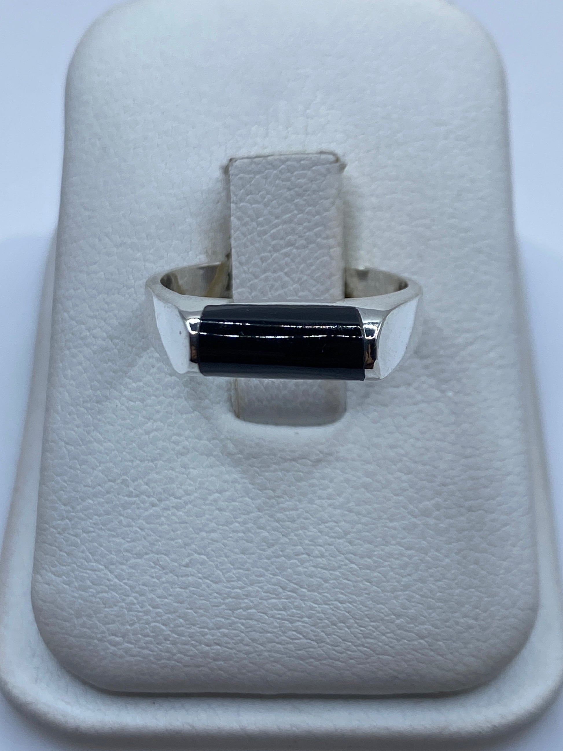 Anillo de plata .925 con ónix negro rectangular en mano de mujer, vista frontal