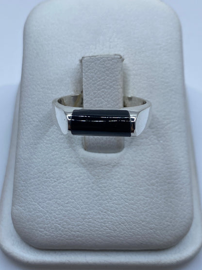 Anillo de plata .925 con ónix negro rectangular en mano de mujer, vista frontal