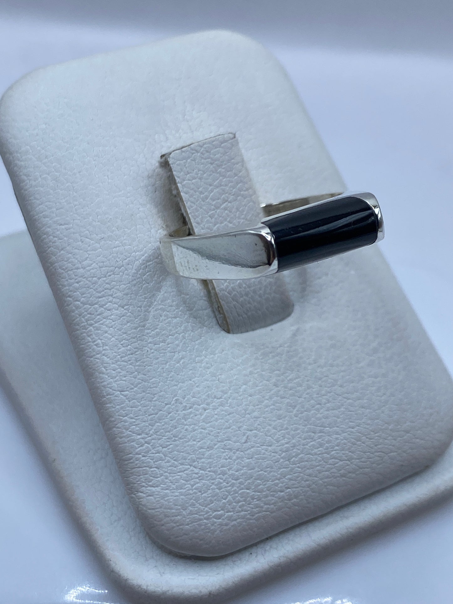 Detalle lateral del anillo minimalista de ónix y plata, mostrando pulido