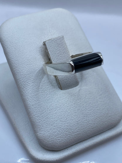 Detalle lateral del anillo minimalista de ónix y plata, mostrando pulido
