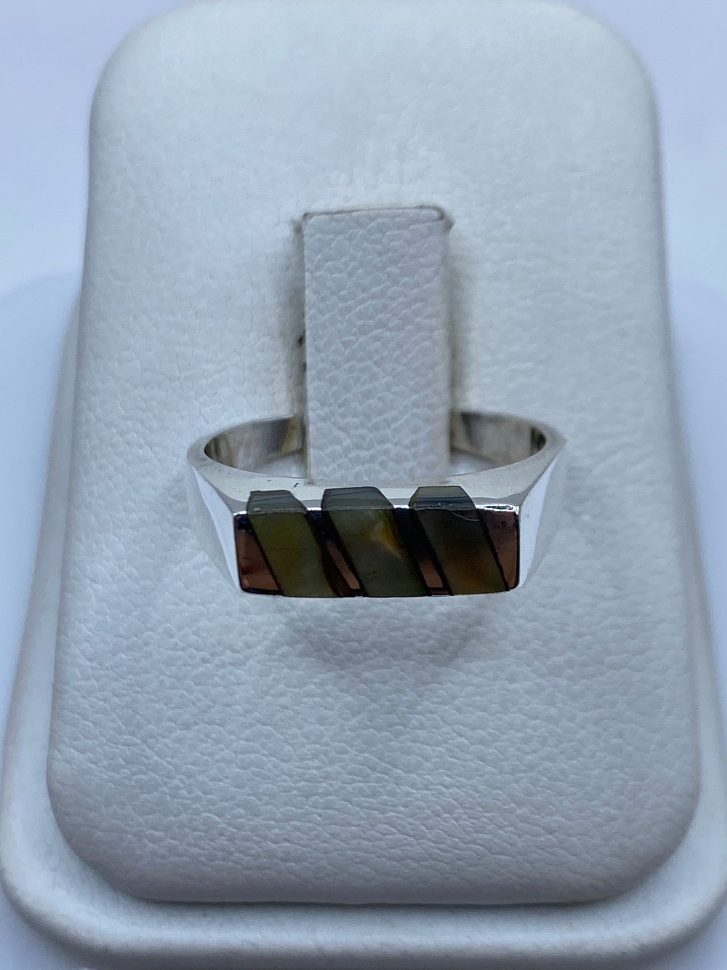 Anillo de plata minimalista con piedra natural rectangular, visto desde arriba en estuche blanco