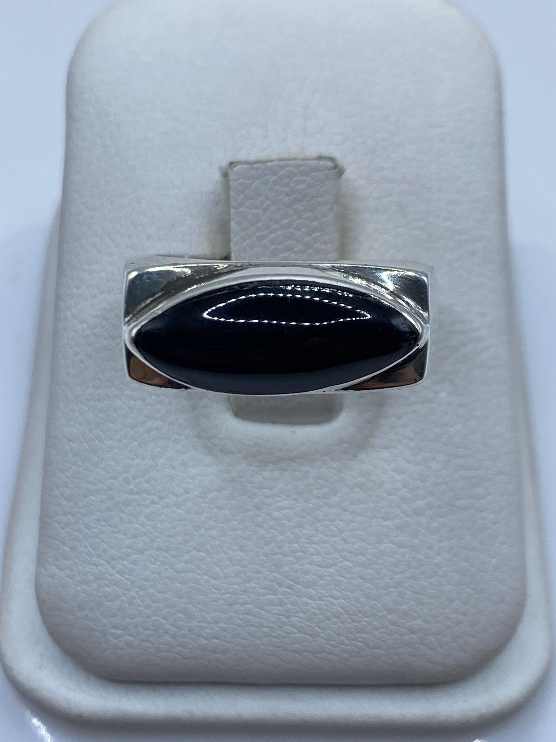 Anillo de plata masivo con ónix negro engastado, talla 8, sobre presentador blanco