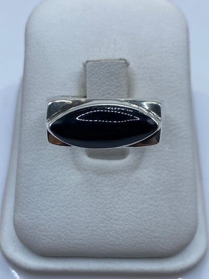 Anillo de plata masivo con ónix negro engastado, talla 8, sobre presentador blanco