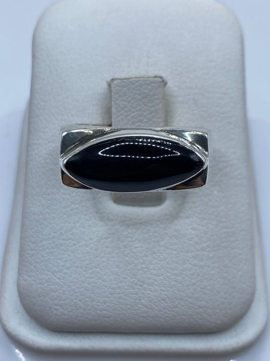 Anillo de plata masivo con ónix negro engastado, talla 8, sobre presentador blanco