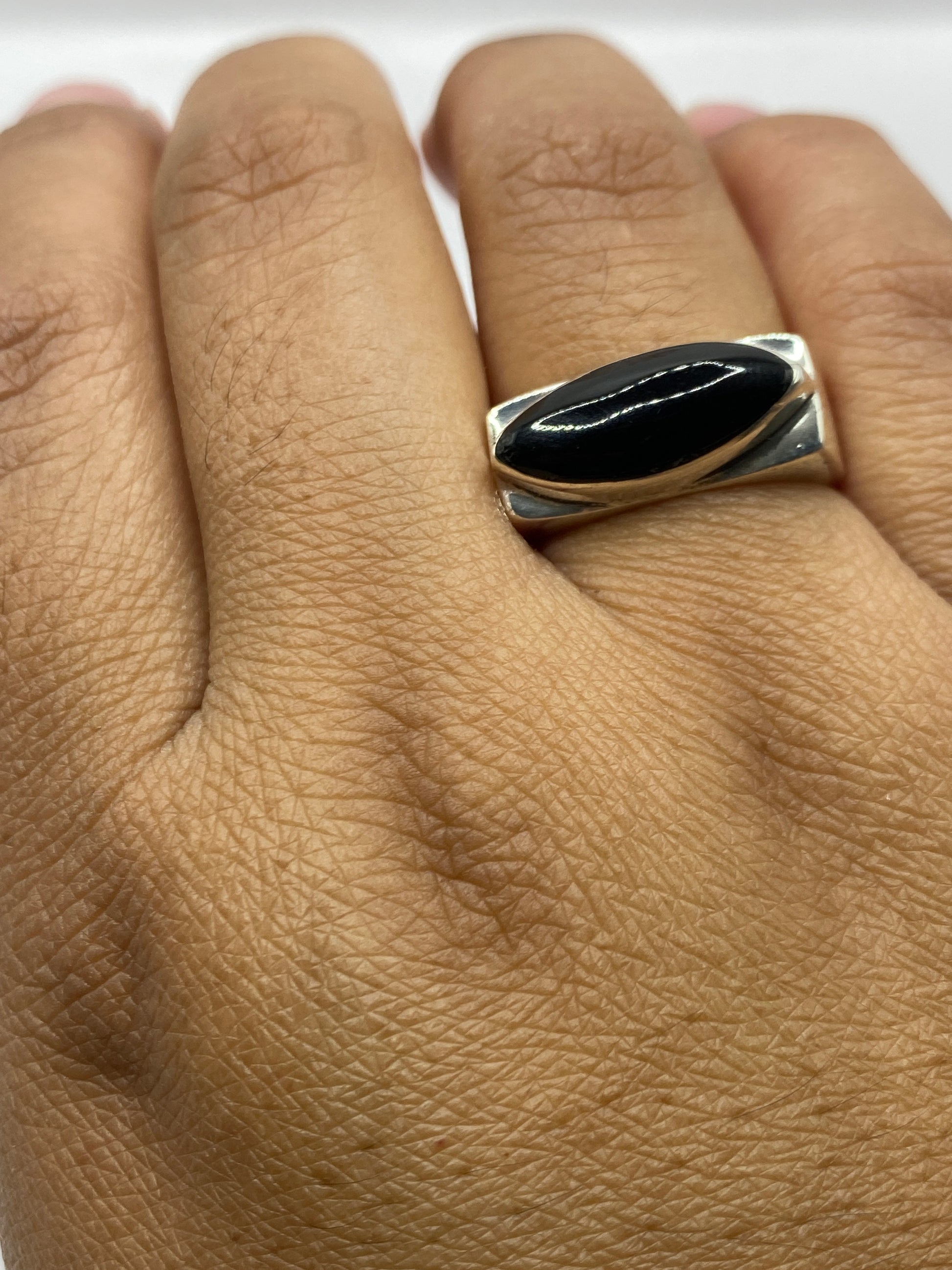 Anillo de plata ónix puesto en mano de hombre, vista superior