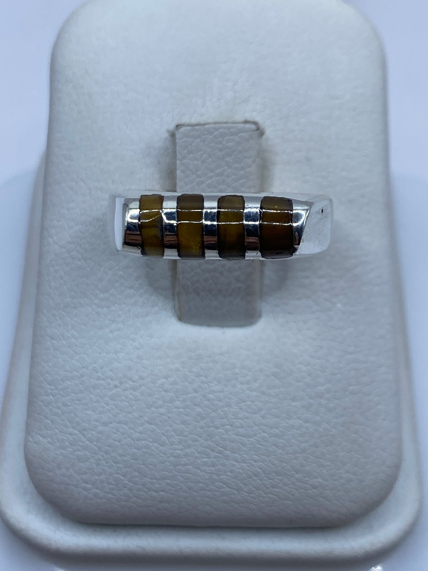 Anillo de plata banda engastado en la mano de una mujer, vista frontal