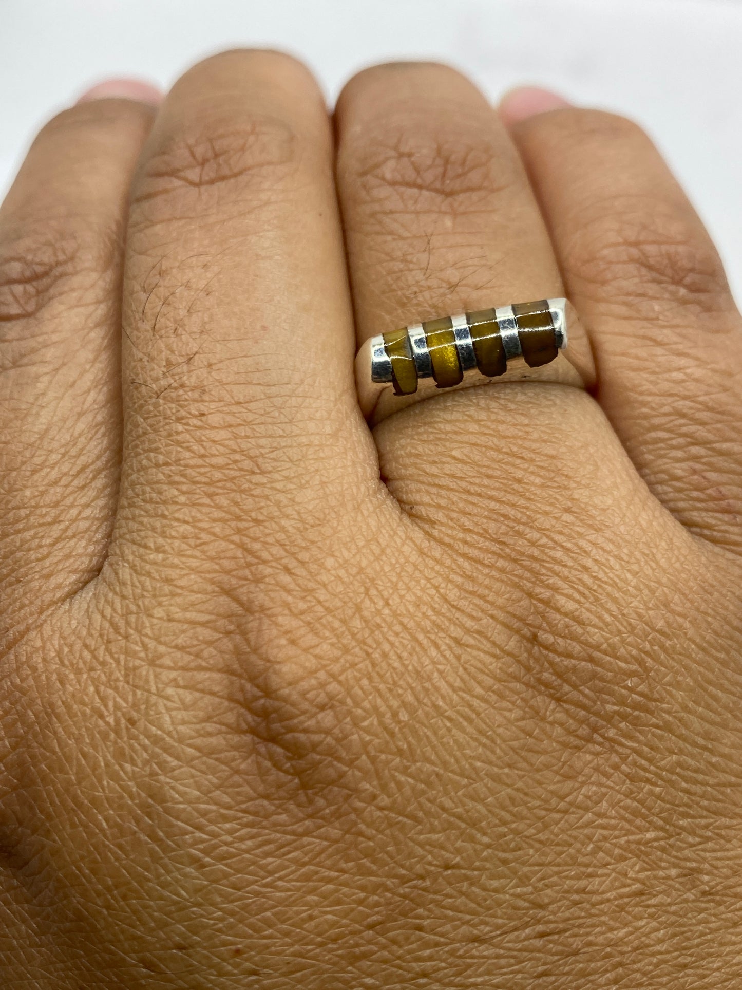 Anillo de plata sobre fondo plateado mostrando grosor de la banda